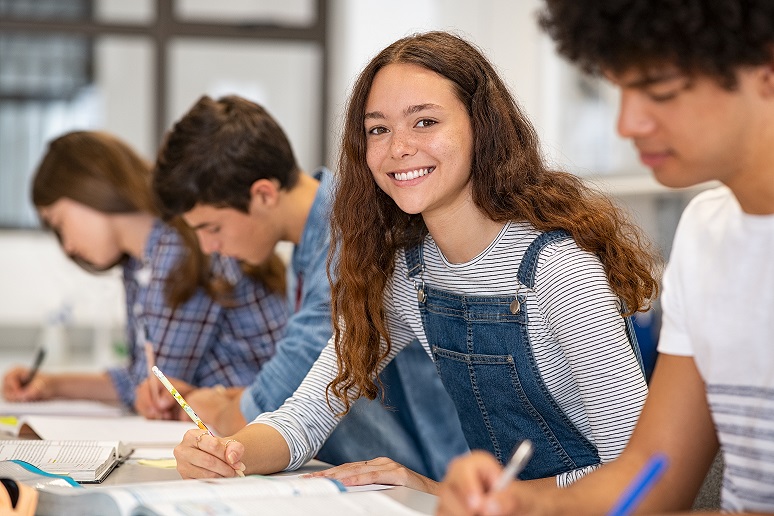 Satisfied,Young,Woman,Looking,At,Camera.,Team,Of,Multiethnic,Students