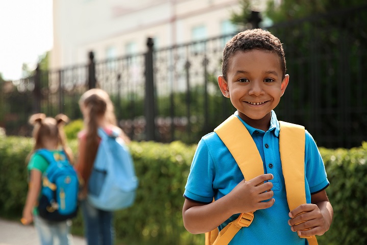 Cute little child with backpack outdoors. Elementary school